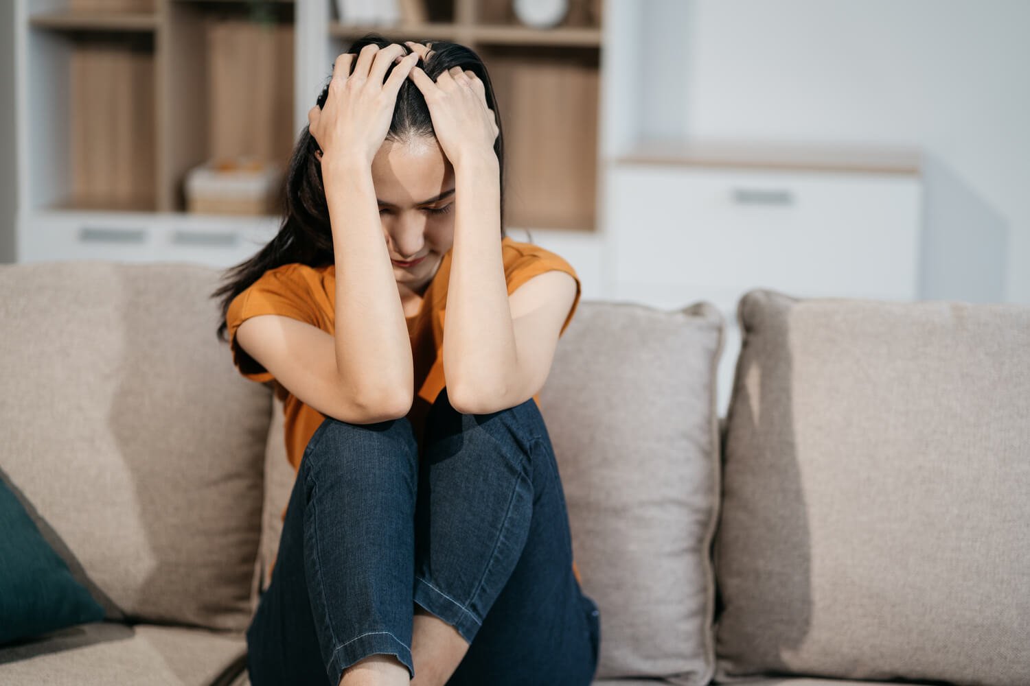 sad-and-depressed-young-female-sitting-on-the-sofa-2XRUQAE.jpg