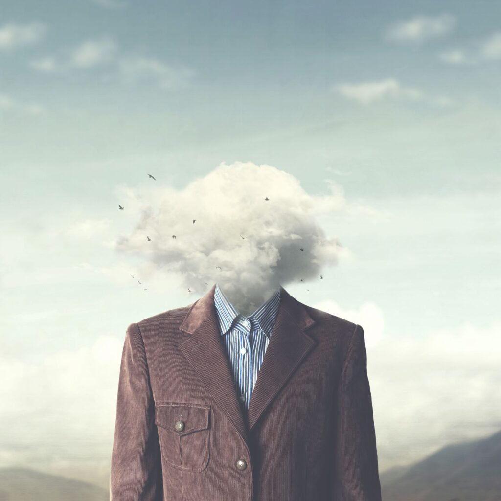 A surreal image of a person with a cloud for a head with birds flying around against a sky backdrop.