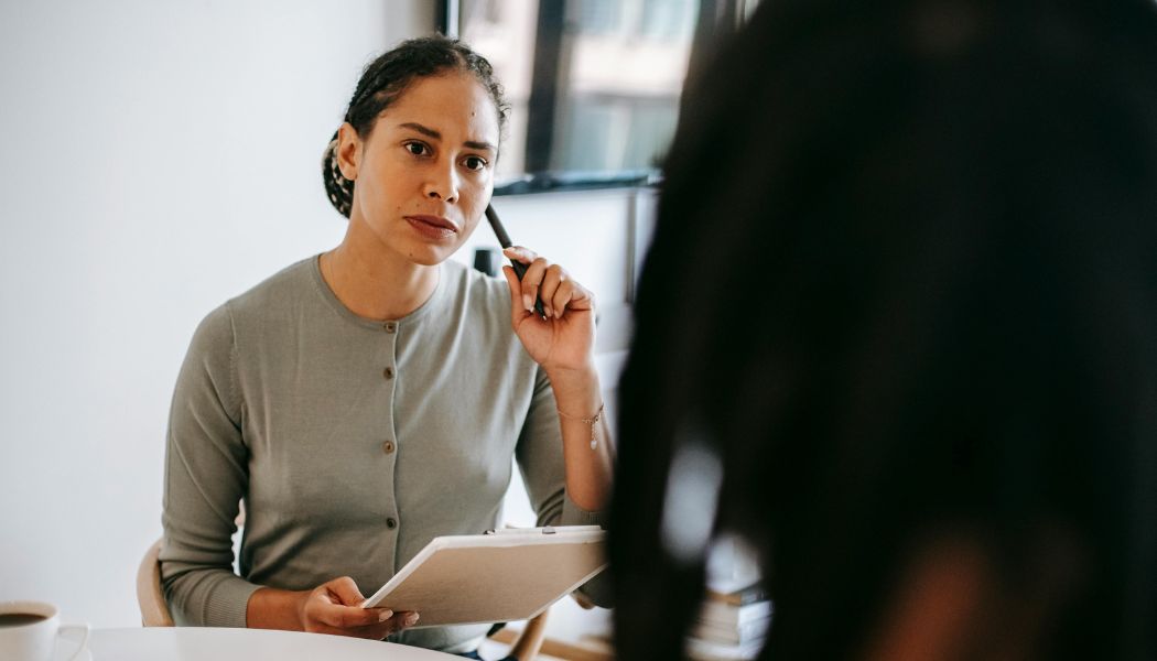 Therapist listening carefully and taking notes during a therapy session.