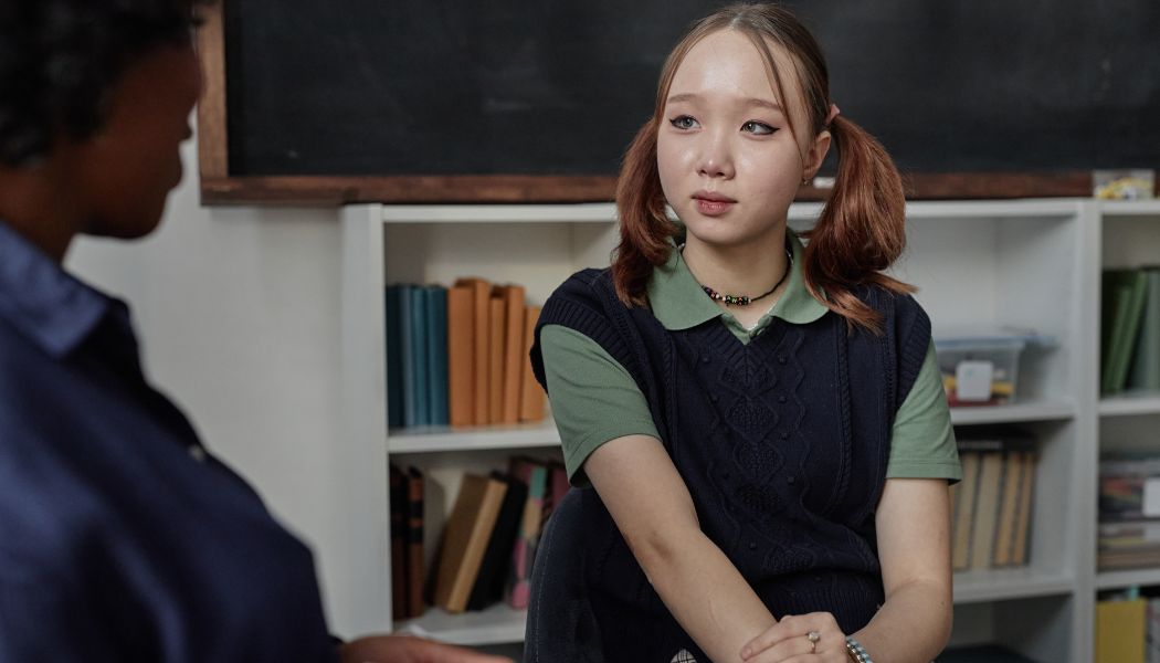 Young woman with pigtails sitting and talking with to a therapist.