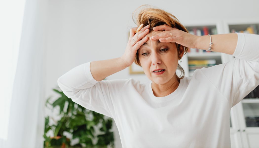 Stressed woman holding her head with both hands.
