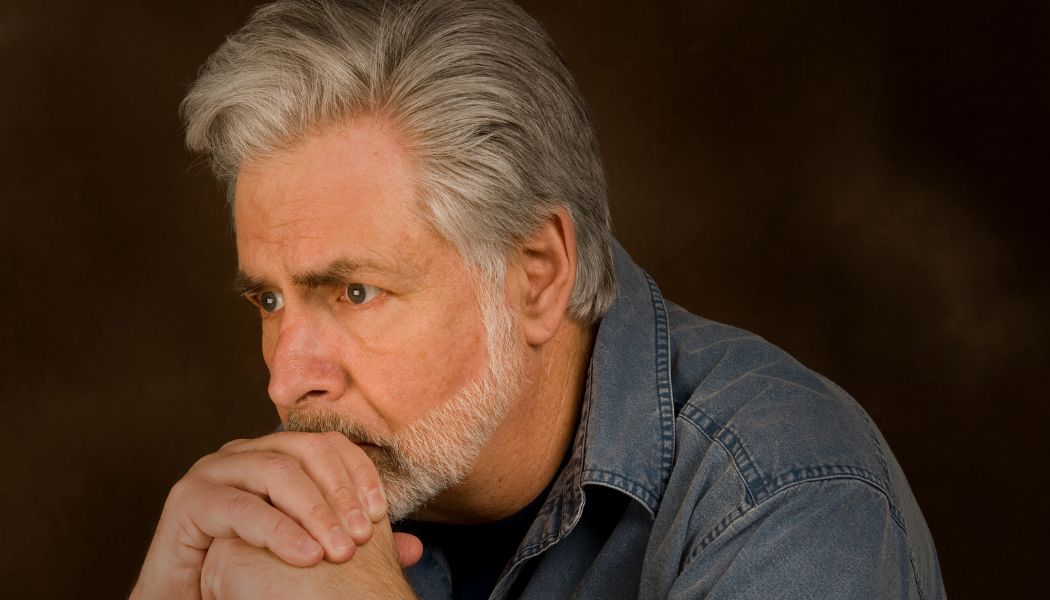 Older man with gray hair looking pensive and deep in thought.